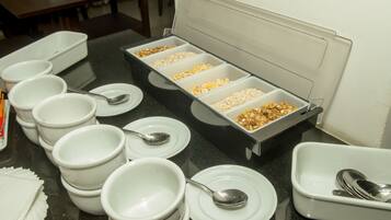 A buffet setup with multiple bowls and trays of food.