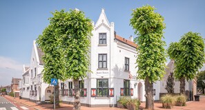 A white building with the sign "Hotel Antiek" and a pedestrian crossing sign. - Hotel Nieuw Antiek (Helden)