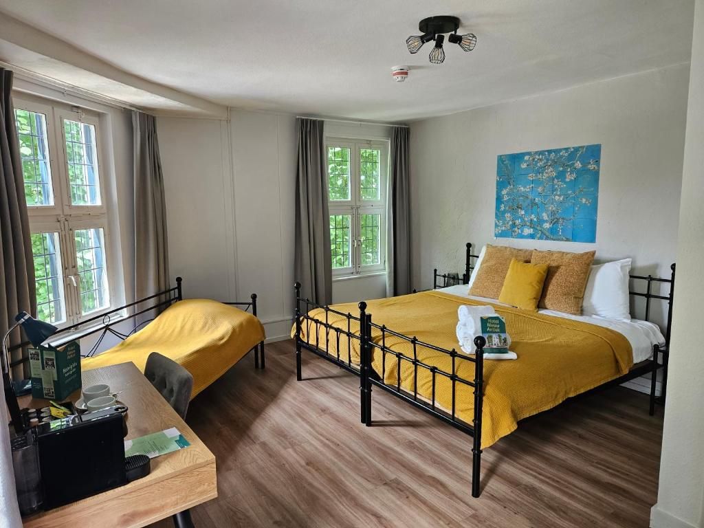 Een kamer met een bed, een bureau en een raam.