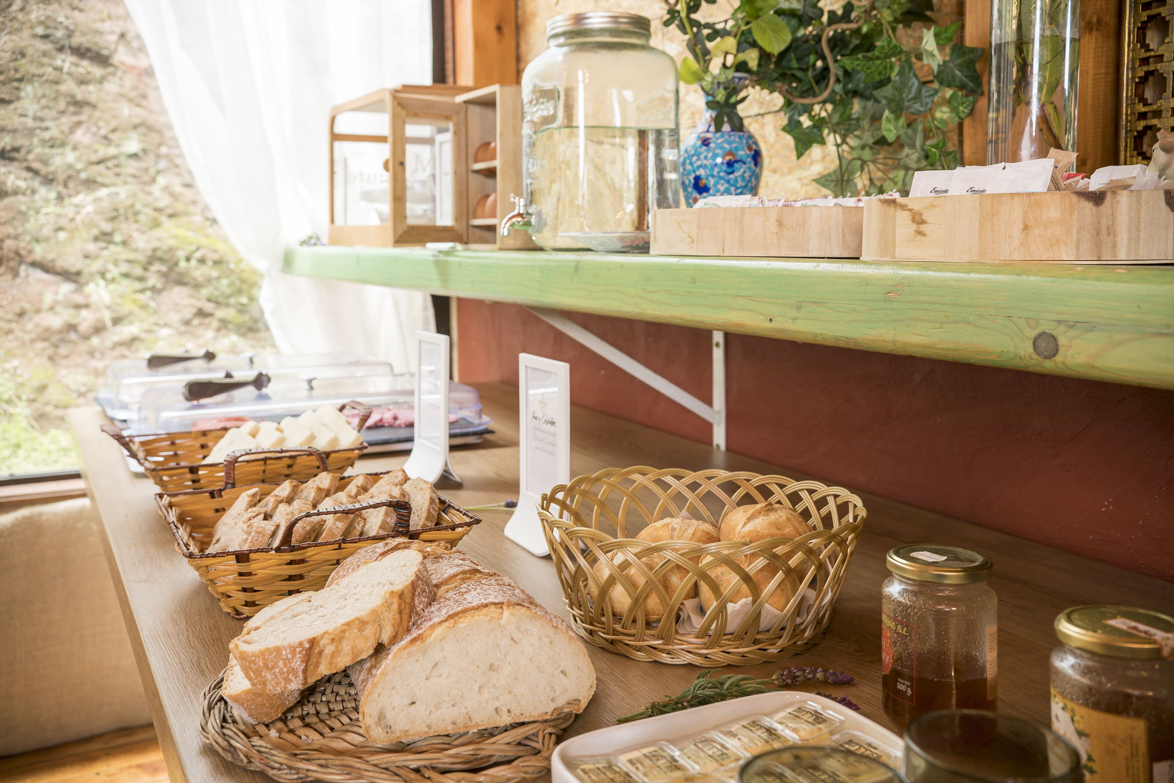 Ein Frühstücksbuffet mit Brot, Gebäck und Beilagen.