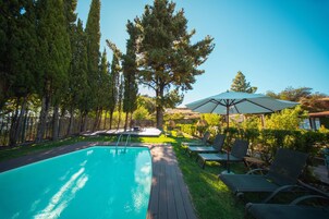 Una piscina al aire libre de temporada, sillones reclinables de piscina