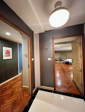 Ein Hotelgang mit Holzboden, einem gerahmten Bild an der Wand und einer Tür mit der Nummer 404.