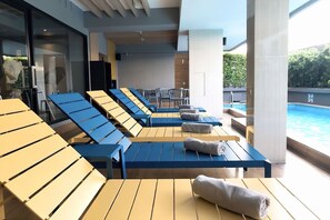 A poolside area with sun loungers and a view of the pool.