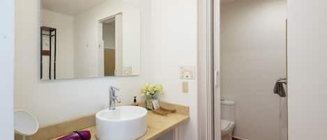 A bathroom with a white sink, a mirror, a towel rack, and a toilet.
