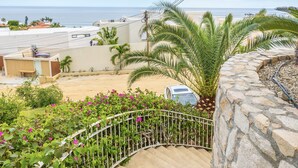 A curved stone staircase leading to a balcony with a view of the beach and ocean. - MariaMar Suites (San José del Cabo)