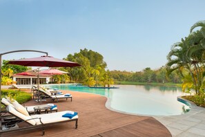 A poolside area with lounge chairs, umbrellas, and a wooden deck. - The Lake Garden Hotel Nay Pyi Taw - MGallery Collection (Naypyidaw)