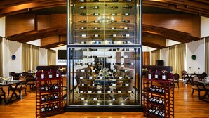 A spacious hotel lobby with a central wine rack, comfortable seating, and a modern wooden ceiling. - The Lake Garden Hotel Nay Pyi Taw - MGallery Collection (Naypyidaw)