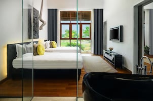 Un dormitorio moderno con una cama grande, televisión, bañera y vistas al exterior.