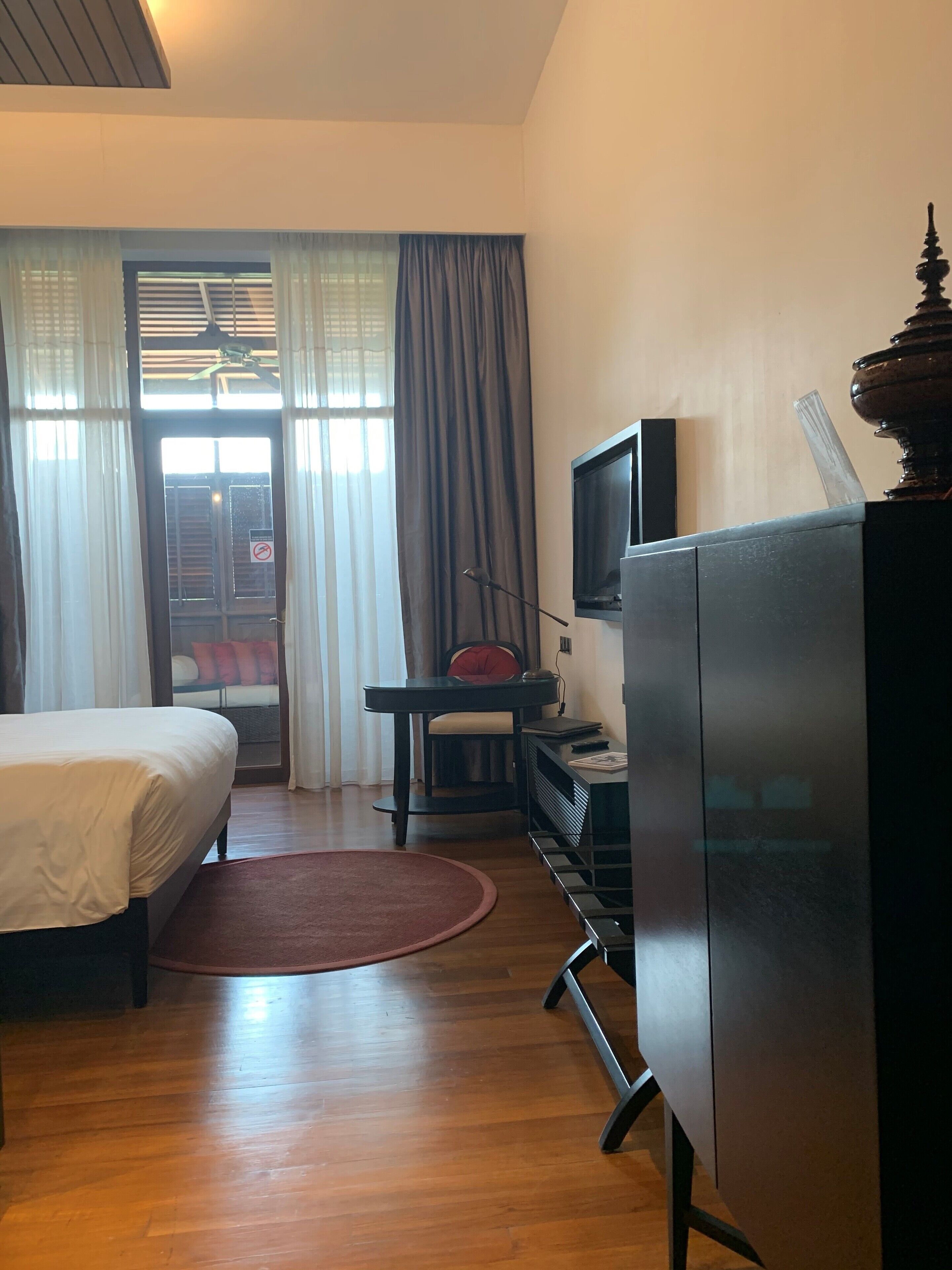 Een hotelkamer met een bed, een bureau, een televisie en een kast.