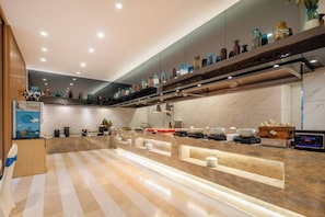 A modern kitchen with a marble countertop, built-in appliances, and a variety of decorative items on shelves.