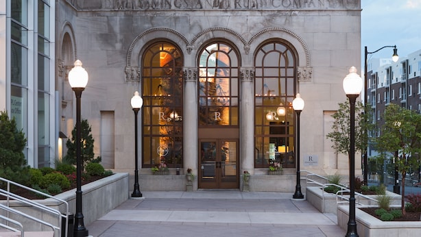 Un bâtiment doté de fenêtres en arc de cercle et d’une enseigne indiquant « Dawkins & Trust Company ».