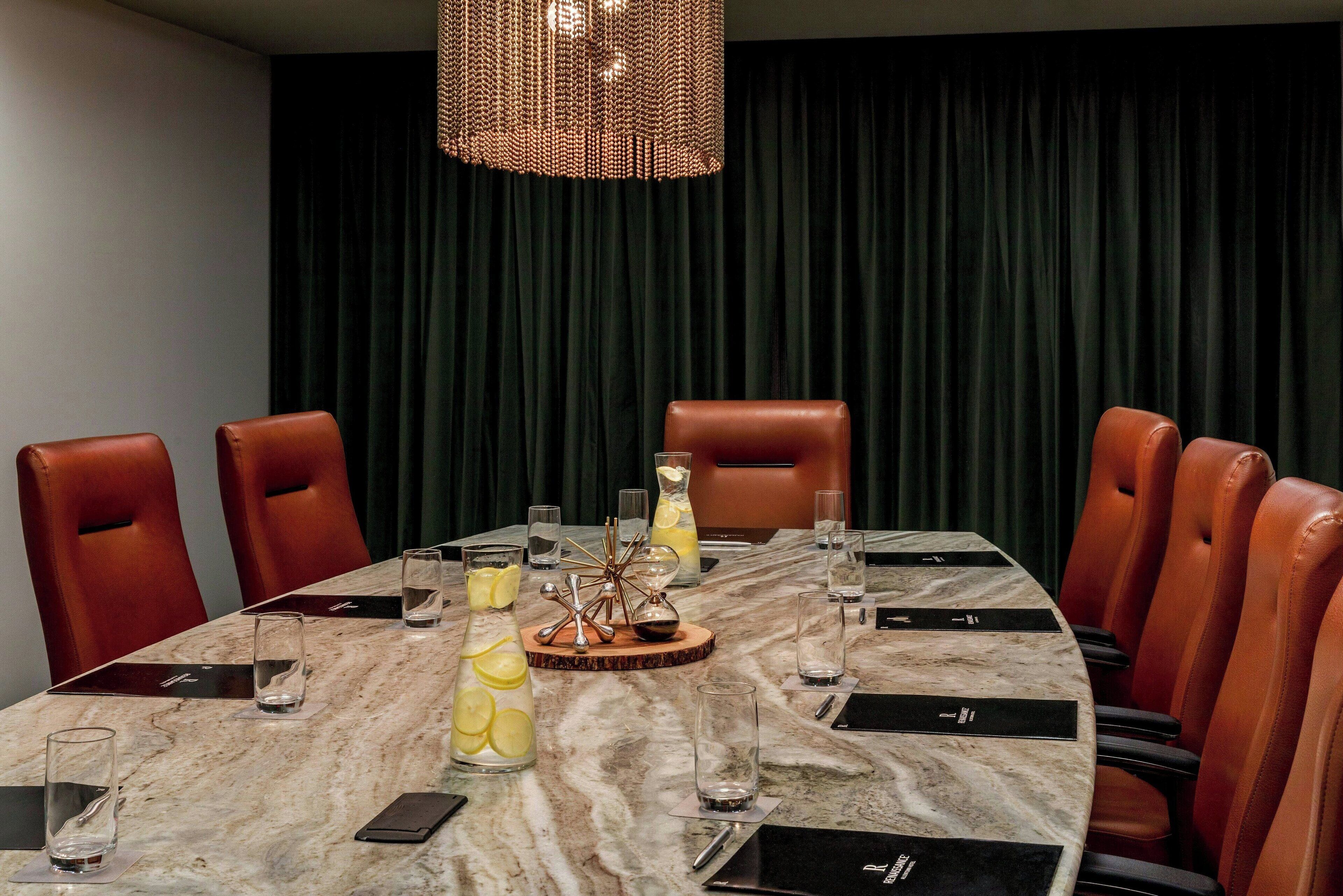 A conference room with a marble table, leather chairs, and a decorative centerpiece.