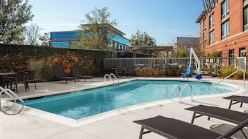 Alberca al aire libre y camastros