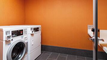 Une buanderie équipée de deux machines à laver à chargement frontal et d’un sèche-linge.