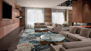 Una sala de estar moderna con un sofá modular, una mesa de centro de vidrio y una chimenea.