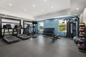A gym with treadmills, elliptical machines, a weight bench, dumbbells, and a cable machine. - Hampton Inn Kenedy (Kenedy)