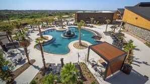 Ein Resort mit zentralem Pool, Liegestühlen und Blick auf die umliegende Landschaft.