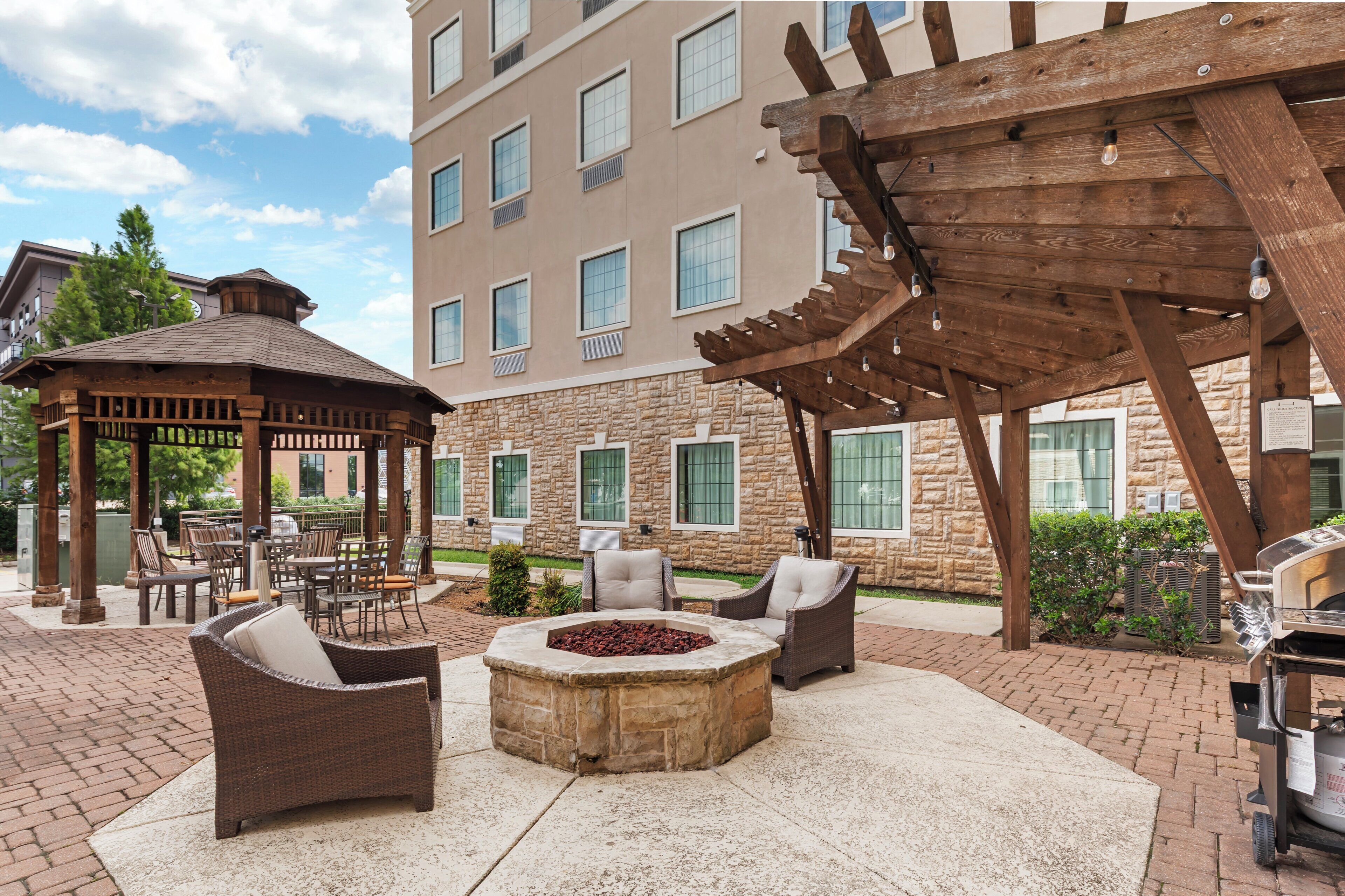 Un espace extérieur aménagé avec une terrasse, un foyer et une pergola.