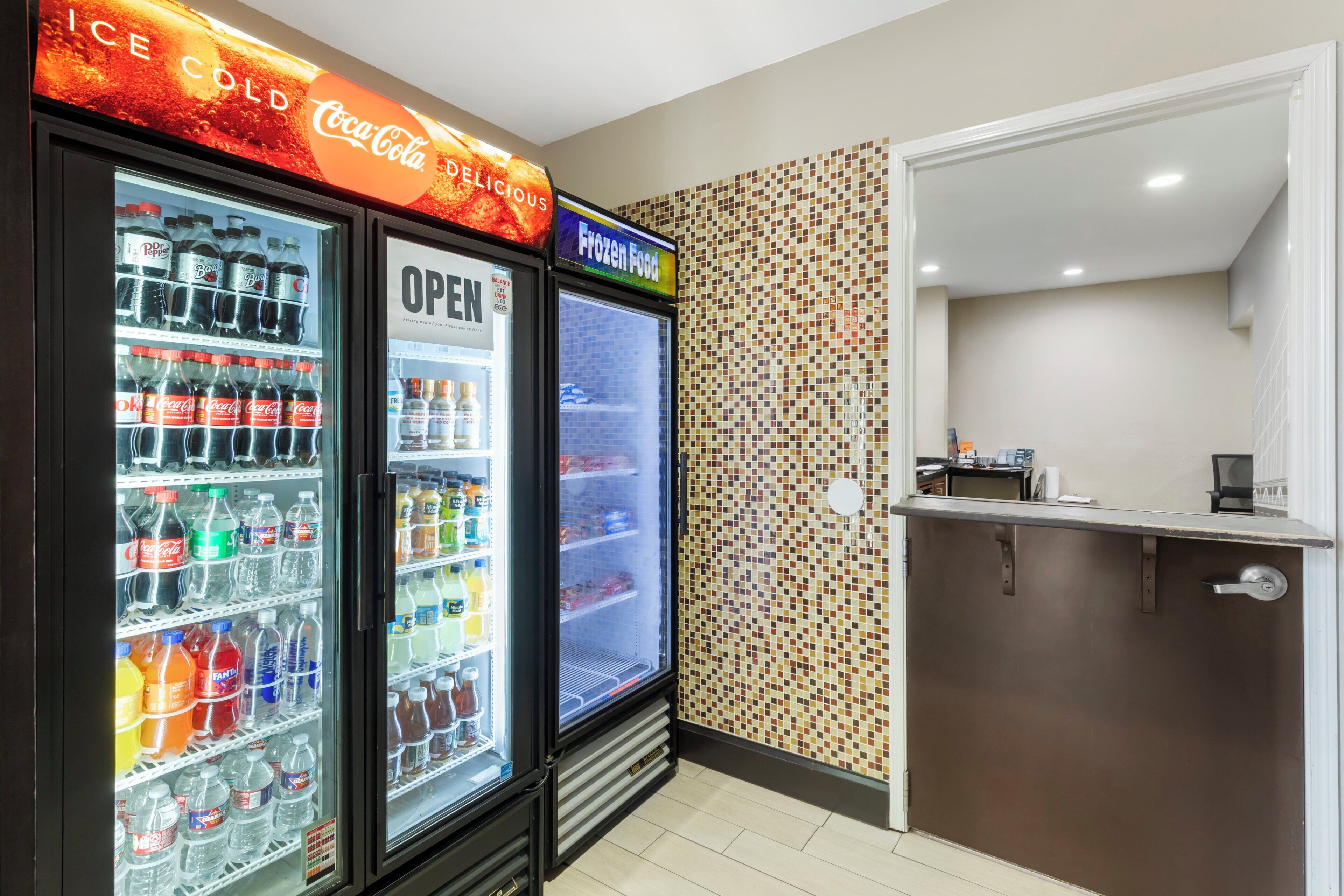 A vending area with Coca-Cola and Dr Pepper refrigerated drinks, a frozen food section, and a small kitchenette area.