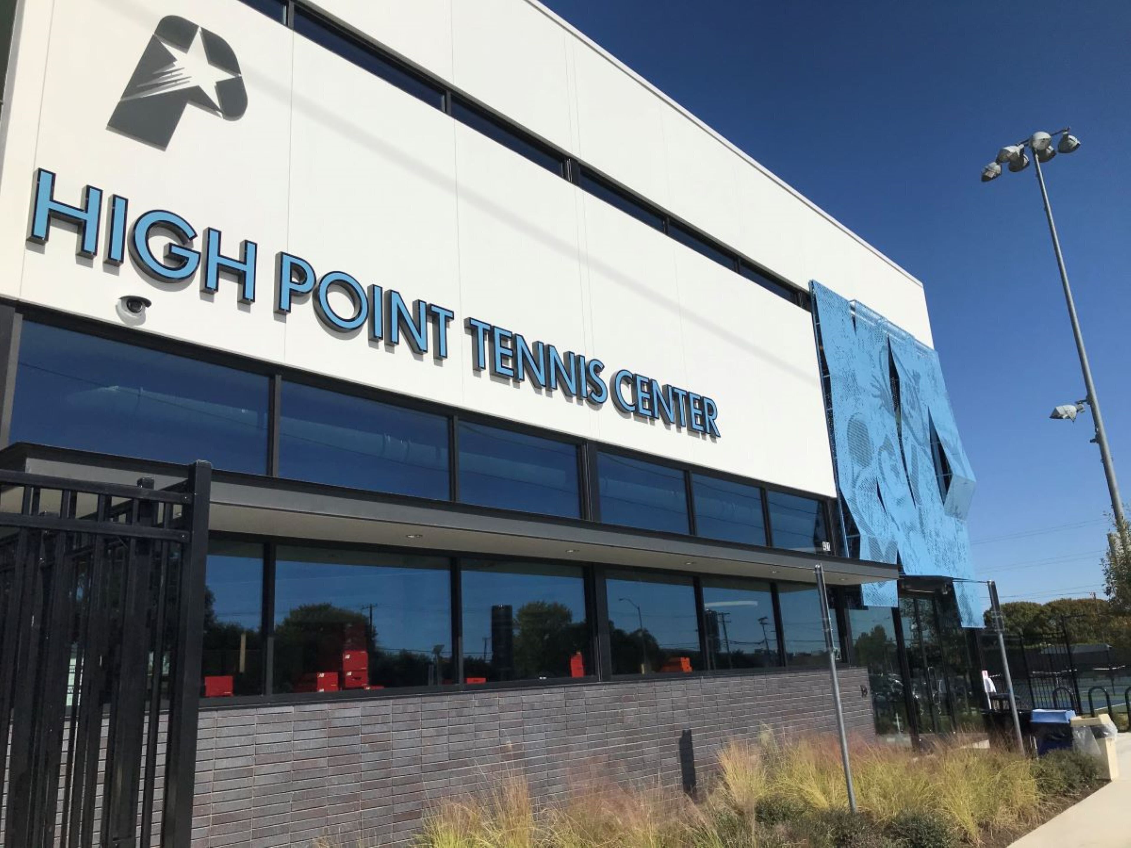 A building with a sign reading "High Point Tennis Center".