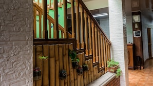 A staircase with a wooden railing and a brick wall.