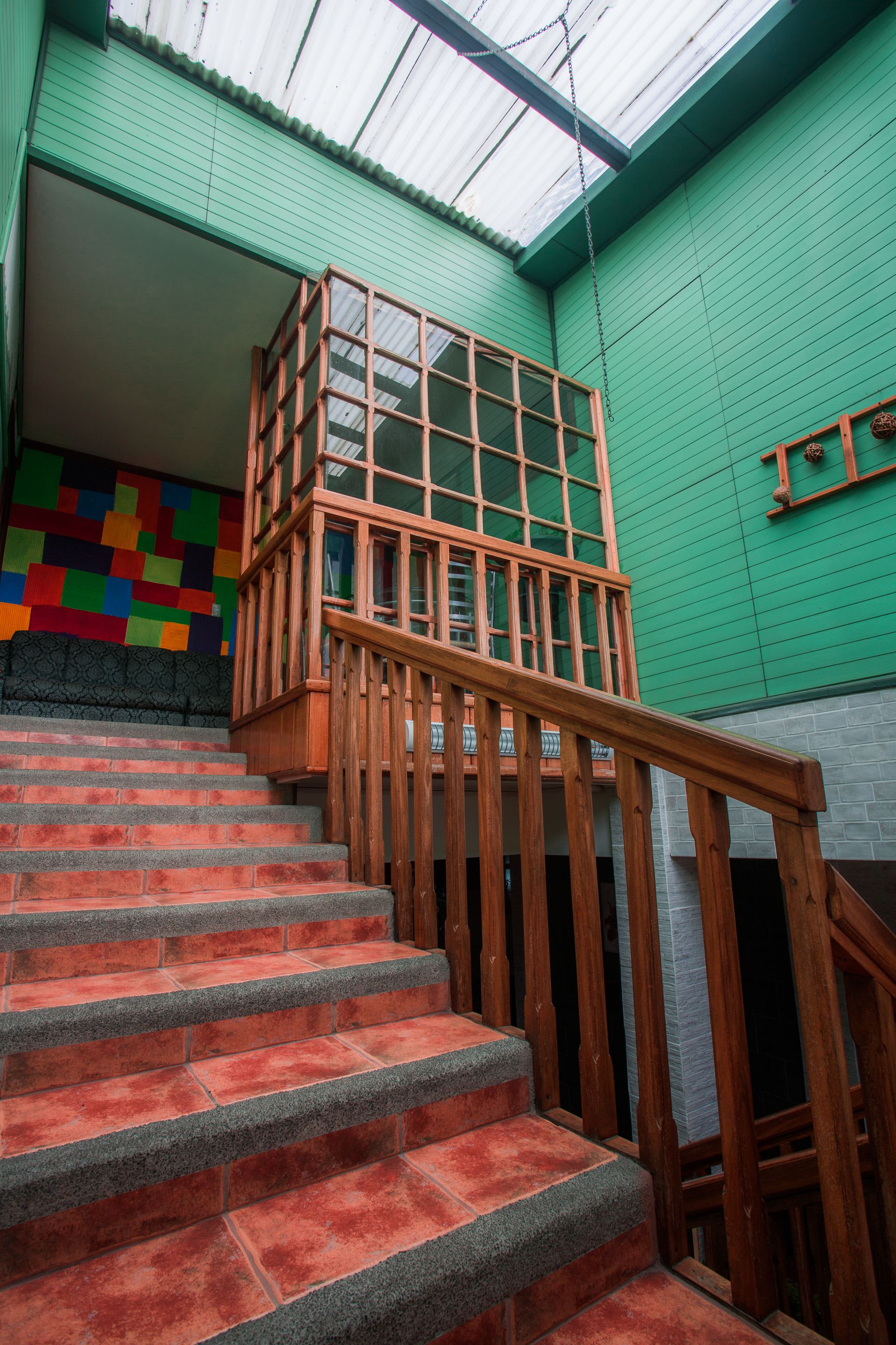A staircase with wooden railings leading to a balcony with a glass railing.