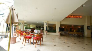 A spacious indoor area with multiple tables and chairs, a reception desk, and a decorative ceiling. - Hotel Real de Minas San Luis Potosi (San Luis Potosi)