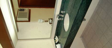 Un baño con inodoro, lavabo y zona de ducha.
