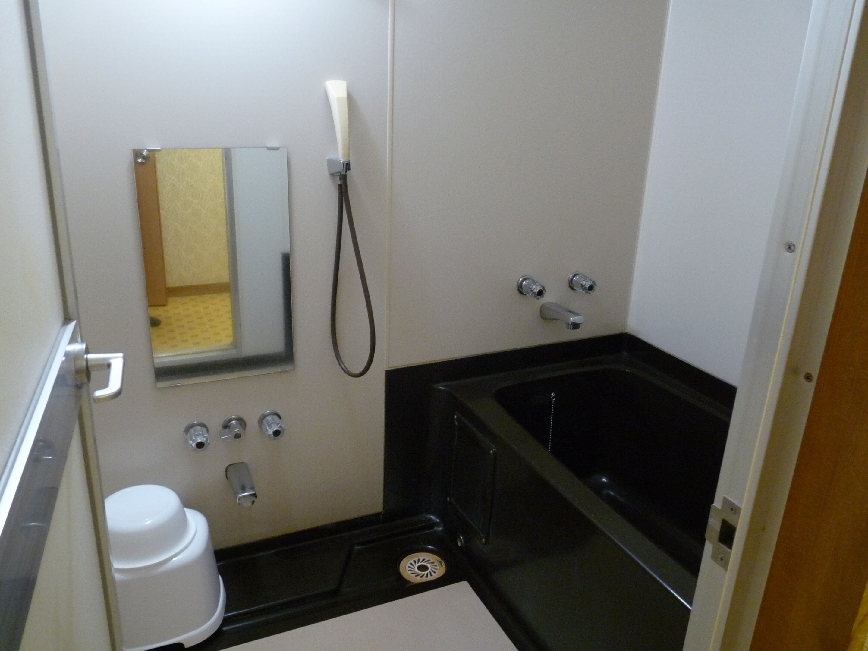 Un baño pequeño con inodoro, lavamanos, espejo y bañera.