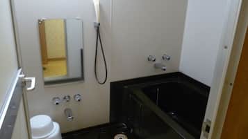 Un baño pequeño con inodoro, lavamanos, espejo y bañera.