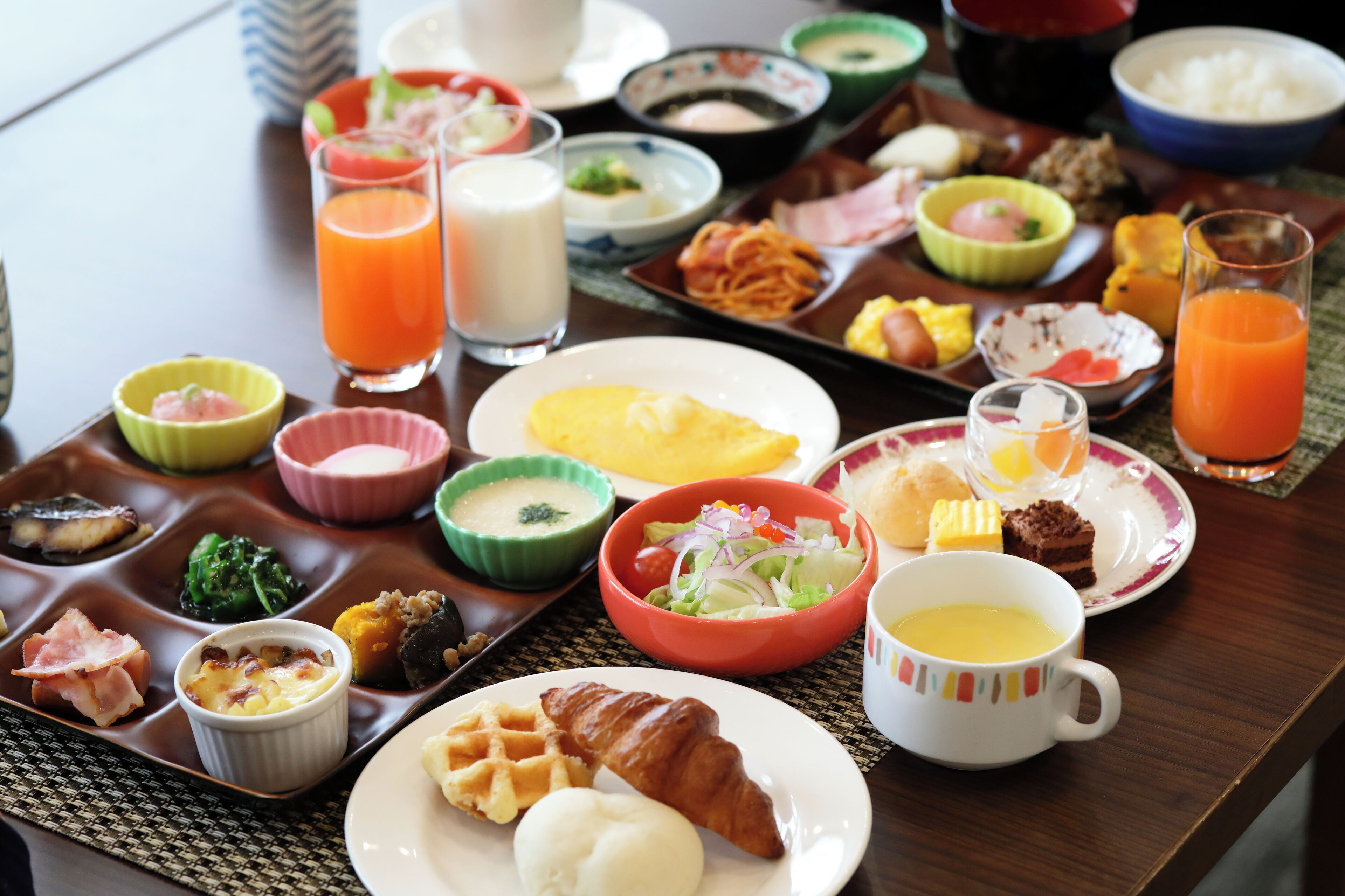 A variety of breakfast items on a tray including eggs, toast, and fruit.