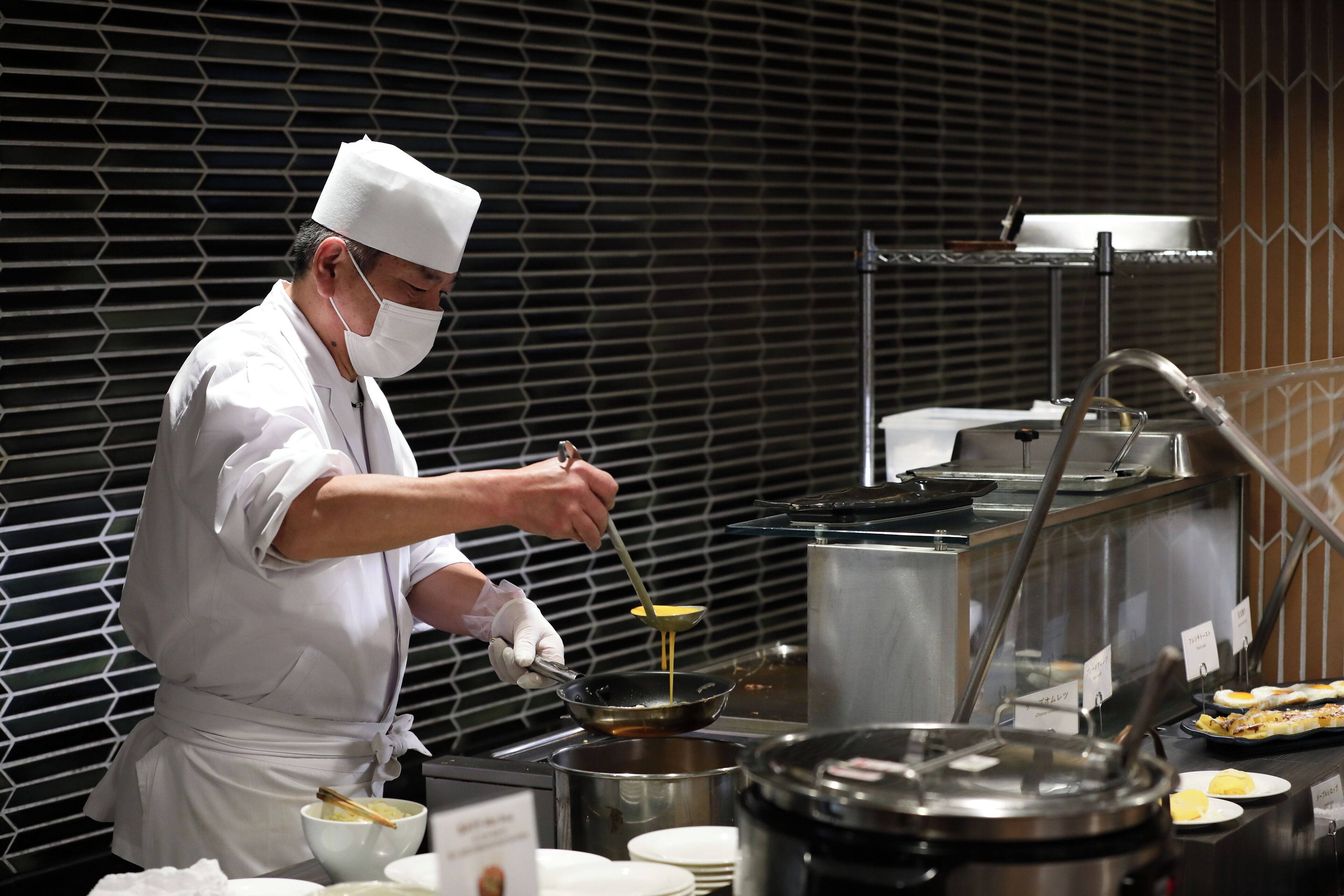 Un chef con uniforme blanco preparando comida en una cocina.