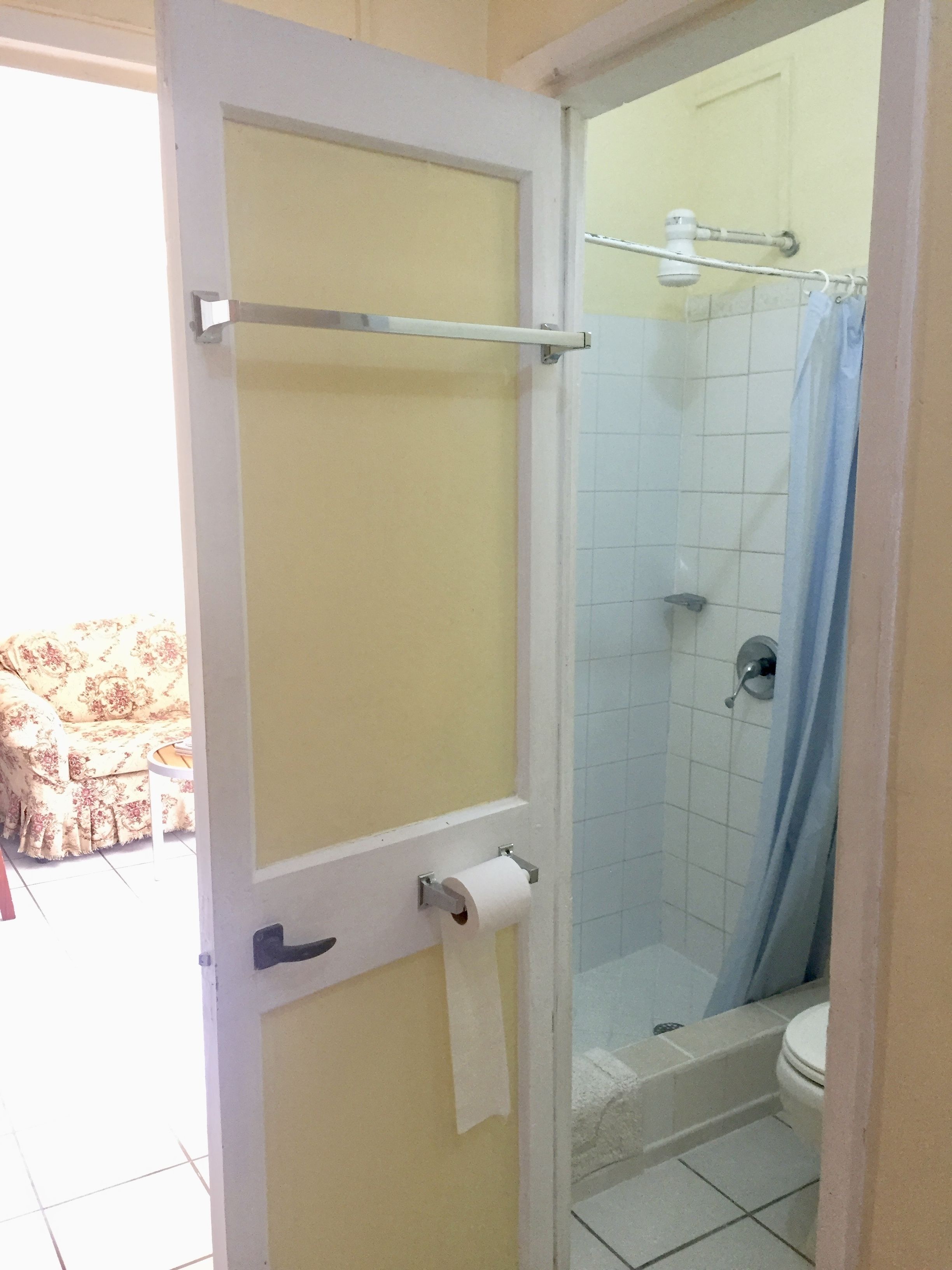 Ein Badezimmer mit Dusche, Toilette und Handtuchhalter.