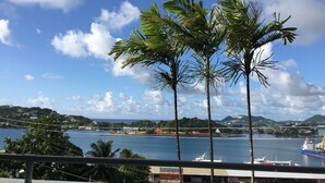 Une vue sur la côte, avec des palmiers, une marina et un ciel dégagé.