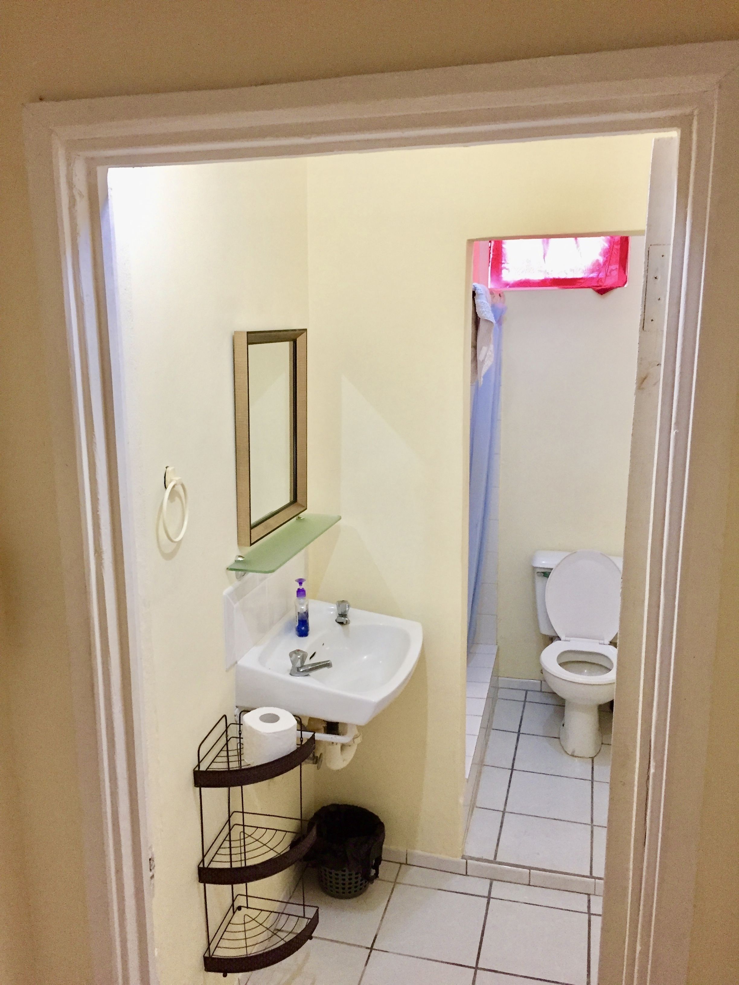A small bathroom with a sink, toilet, and a mirror.