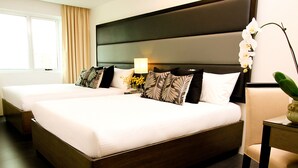 Ein Hotelzimmer mit einem großen Bett, einem Nachttisch mit Lampe und einem Sessel.