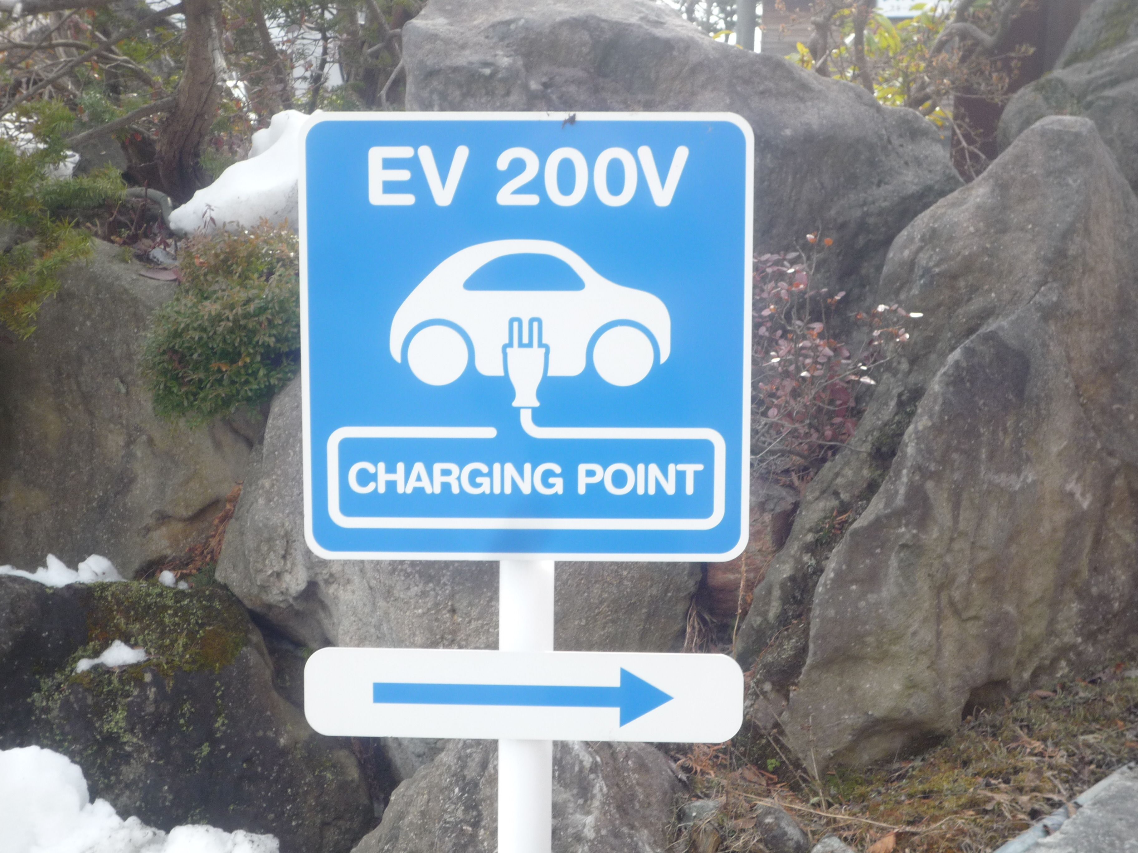 A sign indicating an EV 200V charging point.