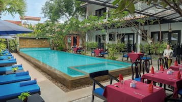 Alberca al aire libre y camastros