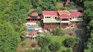 A large resort with multiple buildings, a swimming pool, and lush greenery. - Villa Caprí (Gros Islet)