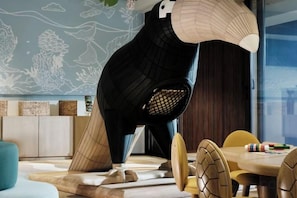 A modern interior with a unique sculpture, a dining area with wooden chairs, and a wall with a nature-themed mural. - Lagen, El Nido (El Nido)