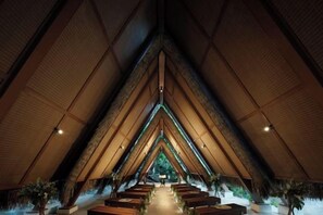 An interior with a central aisle leading to a focal point, surrounded by seating areas. - Lagen, El Nido (El Nido)