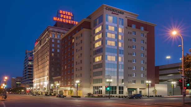 Un hotel de varios pisos con un letrero llamativo que dice "Hotel Perrier Marigot" y "Courtyard by Marriott" en la fachada.