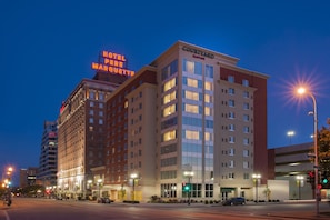 Ein mehrstöckiges Hotel mit einer auffälligen Beschilderung für "Hotel Perrier Marigot" und "Courtyard by Marriott" an der Fassade.
