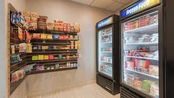 Una sección de alimentos congelados con estantes llenos de diversos aperitivos y bebidas.