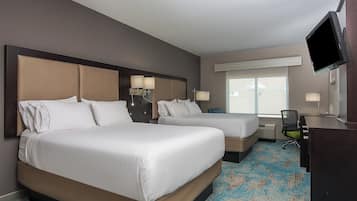 Habitación de hotel con dos camas, un escritorio, una silla y un televisor.