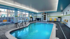 An indoor swimming pool with clear blue water, surrounded by tiled flooring and equipped with a pool ladder. - Fairfield Inn & Suites Little Rock Benton (Benton)