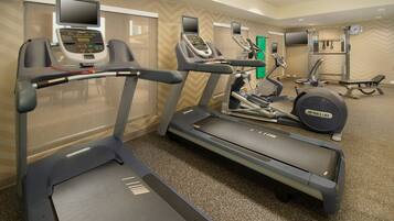 A gym with treadmills, elliptical machines, and weight equipment.