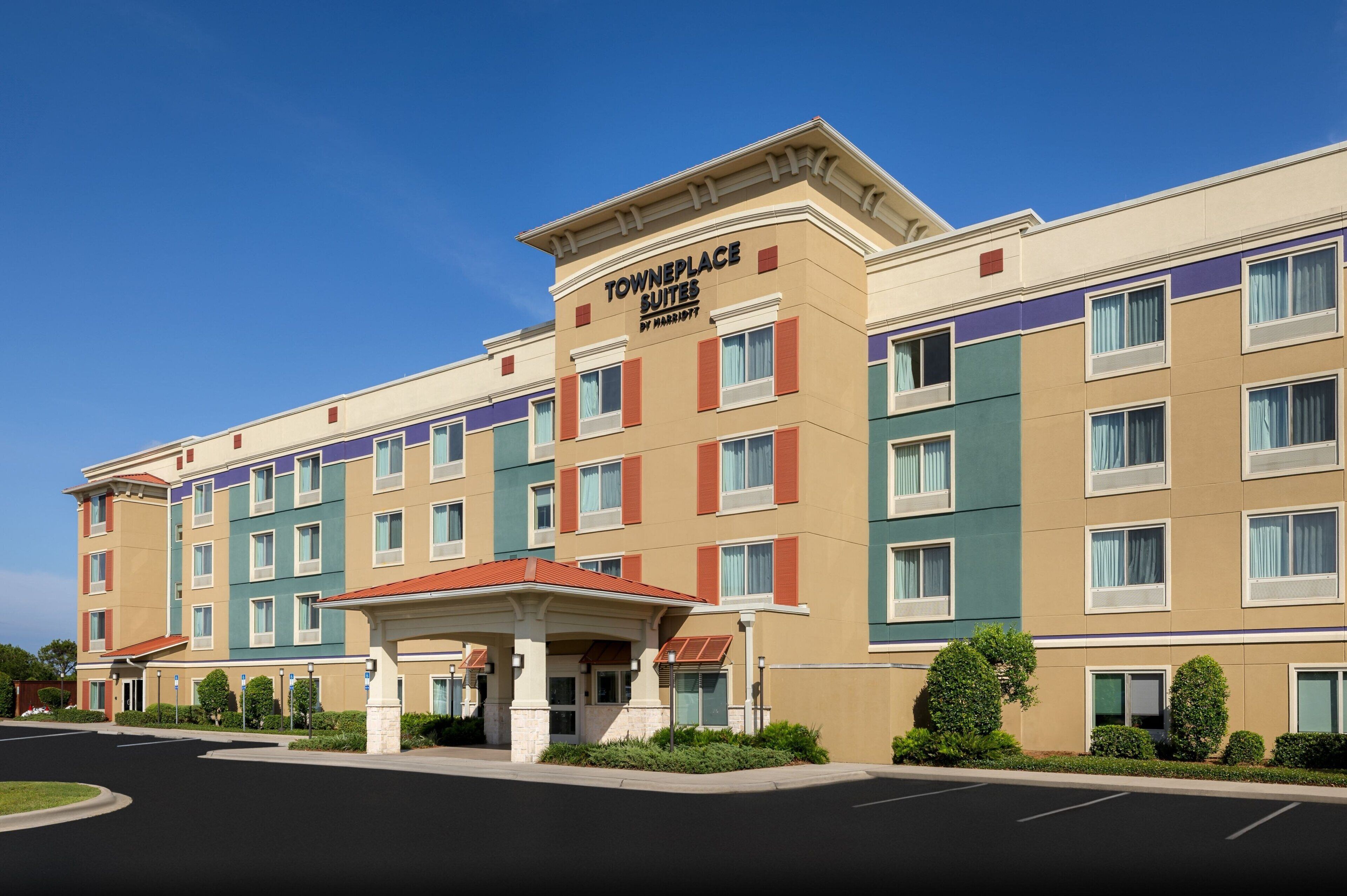 A multi-story hotel with a prominent entrance and a covered waiting area.