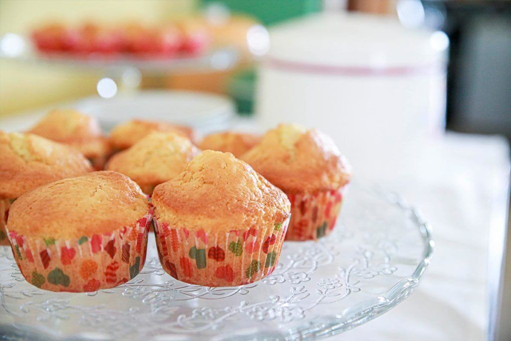 Une assiette en verre contenant des muffins, posée sur une table.