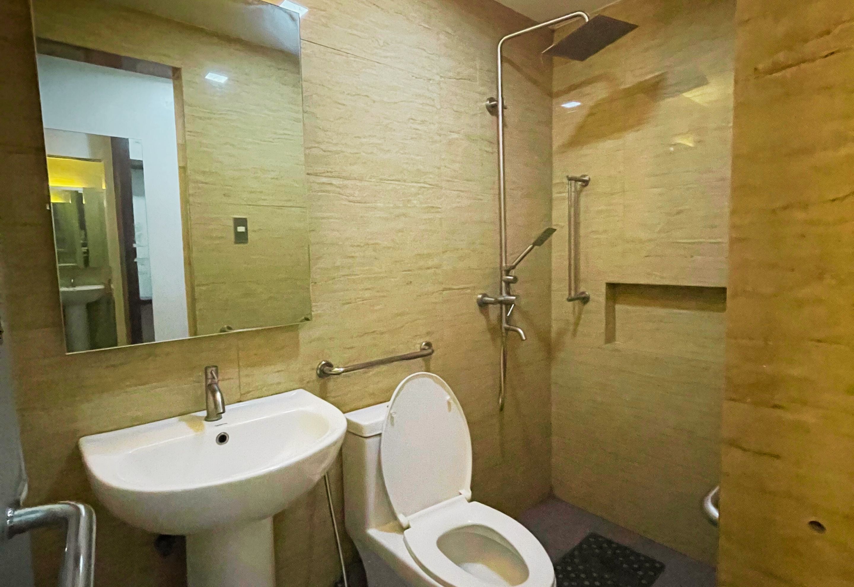 Un baño con lavamanos, inodoro y ducha.